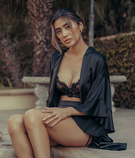 Woman in black lingerie sitting by a pool